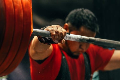 a man is holding a barbell in his hand