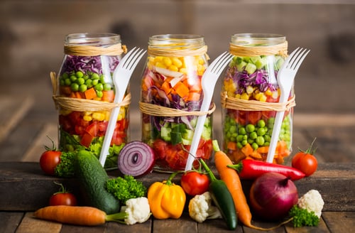 a variety of vegetables in mason jars with forks and forks