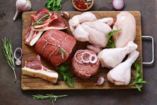 a cutting board with meat and vegetables on a cutting board