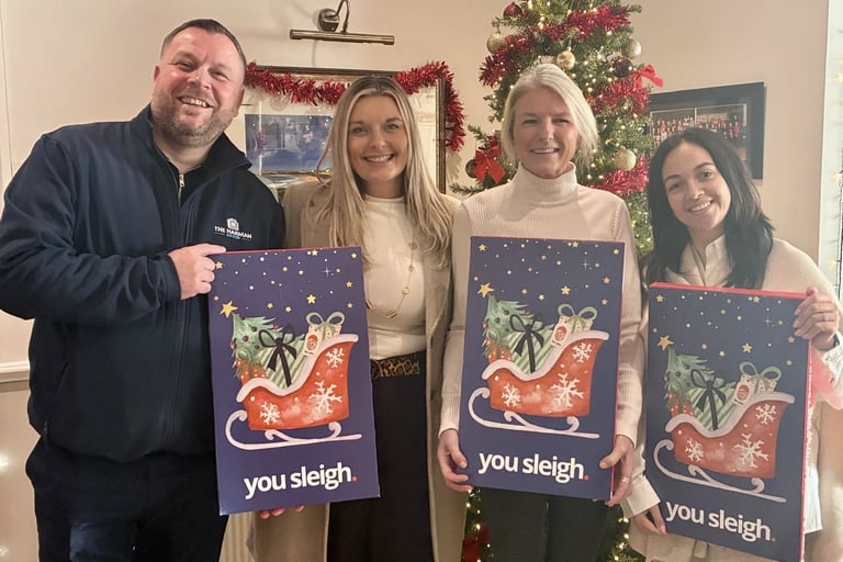 a group of people standing around a christmas tree