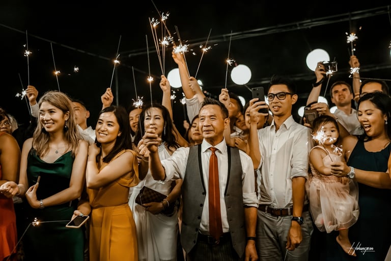 a group of people holding sparklers in front of a crowd