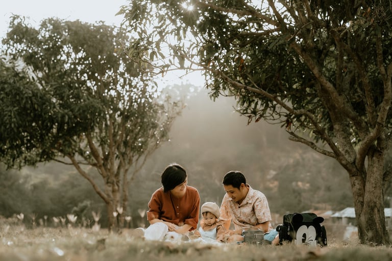 a woman and her husband are sitting on the grass