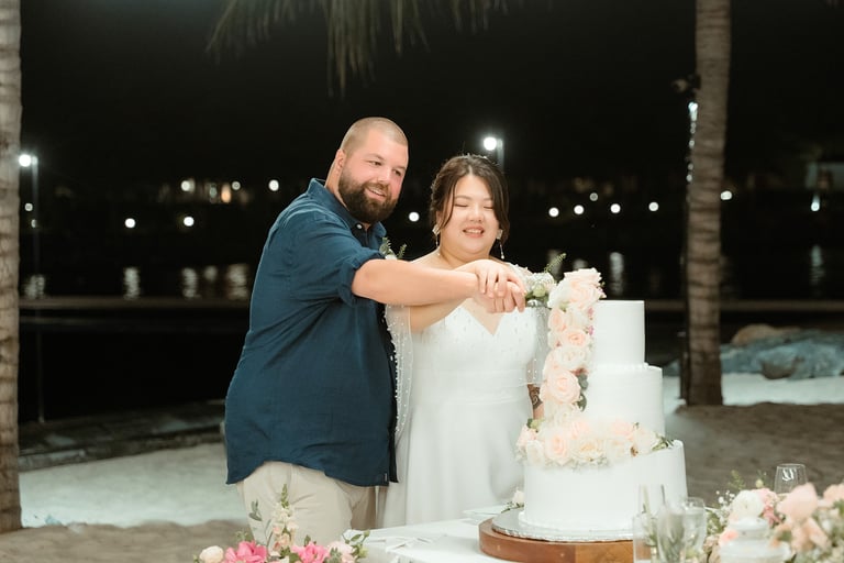 a man and woman standing next to a cake