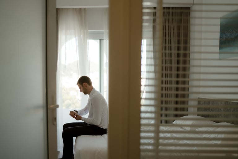 a man sitting on a bed in a hotel room