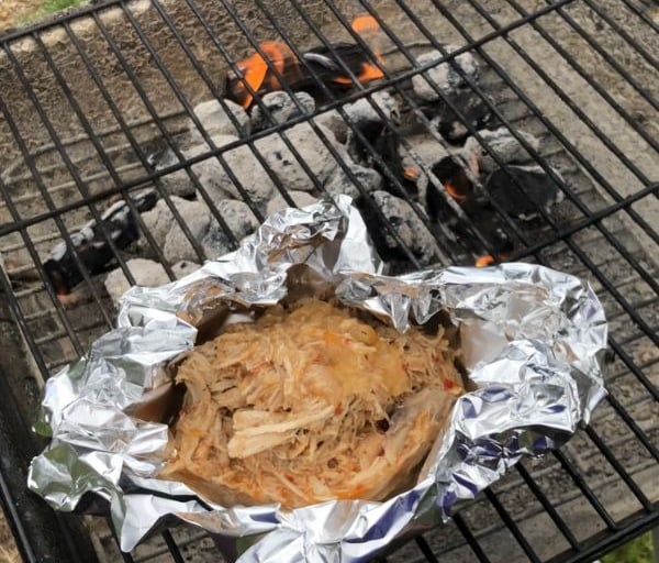 Carolina pulled chicken in foil on Charcoal grill with wood