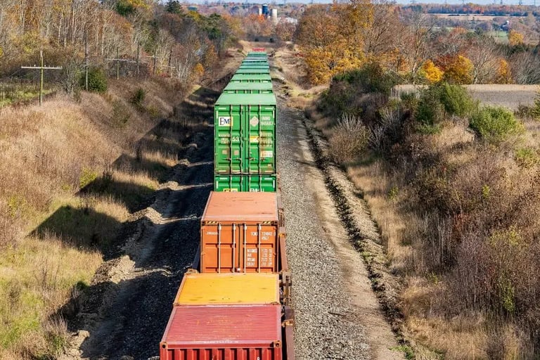 cargo train on track with fall trees of orange and , golden