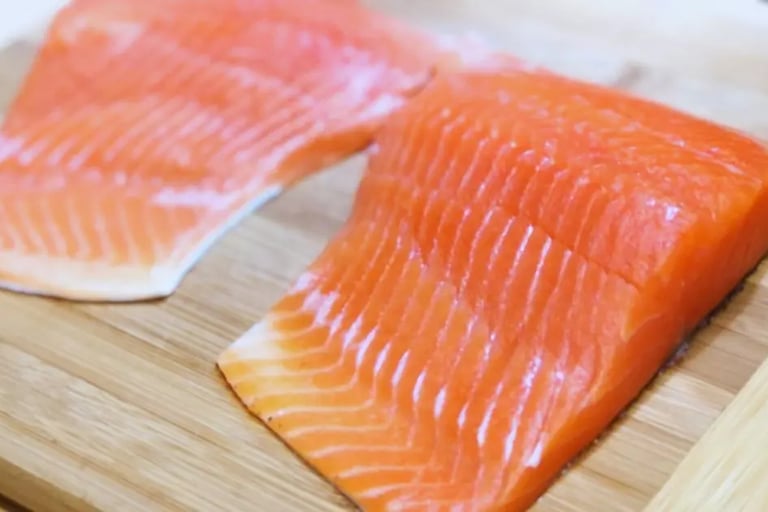 two uncooked steelhead trout fillets on cutting board