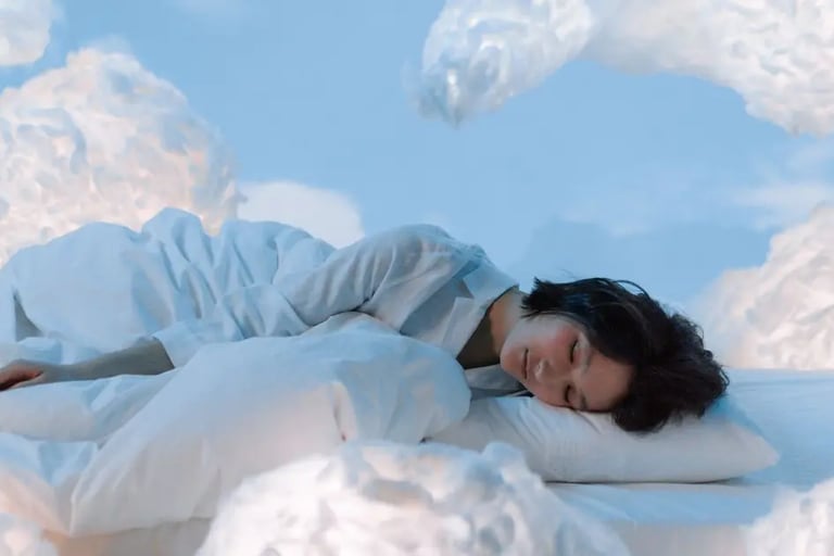 A peaceful image of a woman sleeping, surrounded by soft, fluffy clouds, symbolizing rest and tranquility.