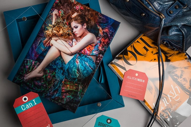 un sac à main avec un magazine Vogue et un book photo et coffret bleu turquoise