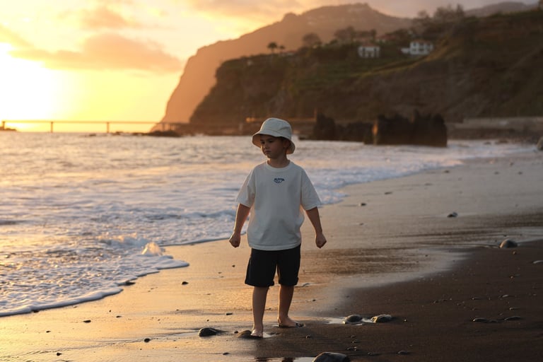 Child on black sand Praia Formosa sunset Madeira Photo by Mihail Zhelezniak