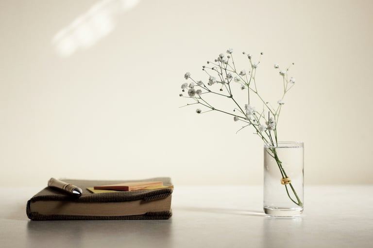 Flower, vase and book on table representing energy cleansing