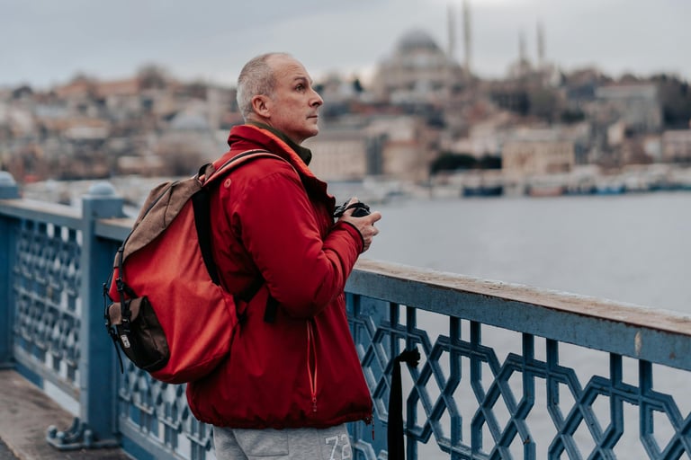 Uomo maturo con zaino osserva una città durante un viaggio da solo.