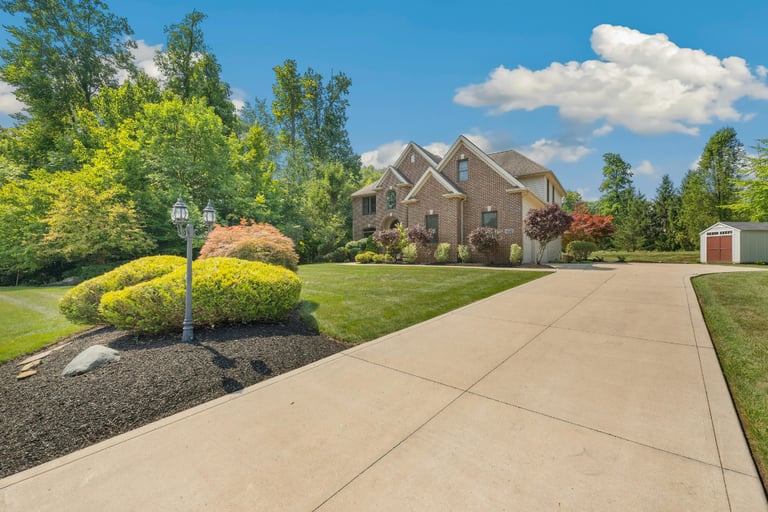 a house with a  concrete driveway and garden