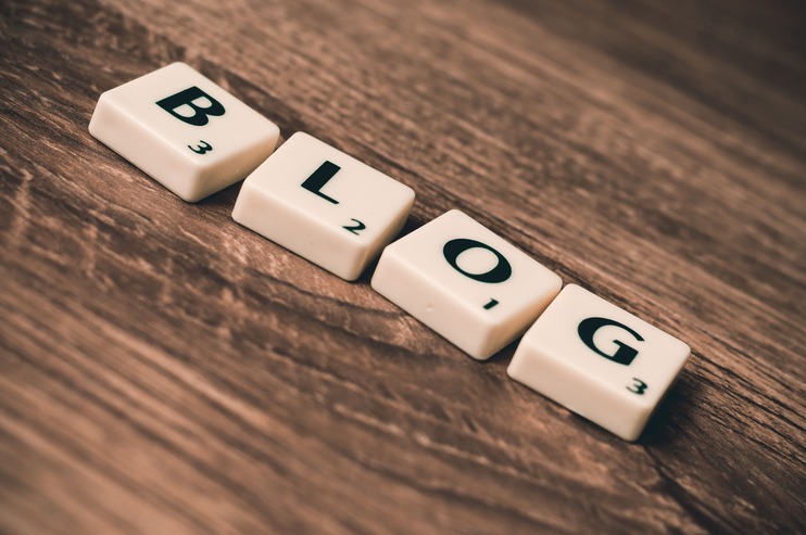 4 piezas del juego scrabble formando la palabra BLOG
