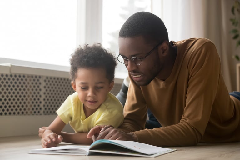 father and toddler read together
