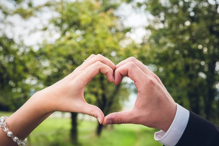 Mains de mariés qui forment un coeur