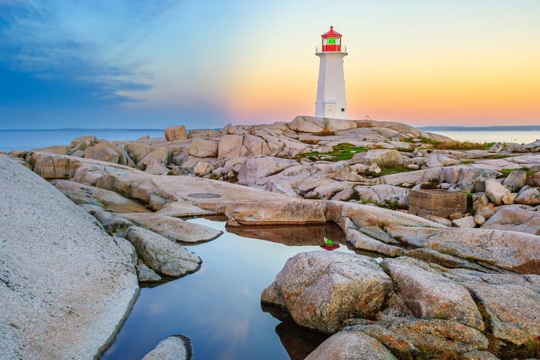 lighthouse with rocks in foreground and sun behind
