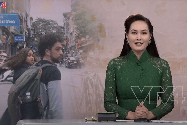 An introduction of a news segment on VTV news. The image shows two foreigners walking around Hanoi, in Vietnam.