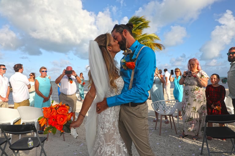 bride and groom walking down the aisle kissing in key biscayne