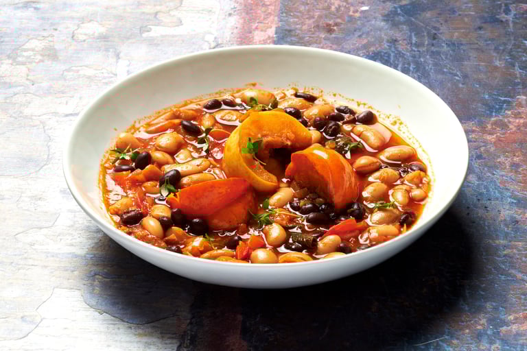 a bowl of beans and pumkin stew in a bowl