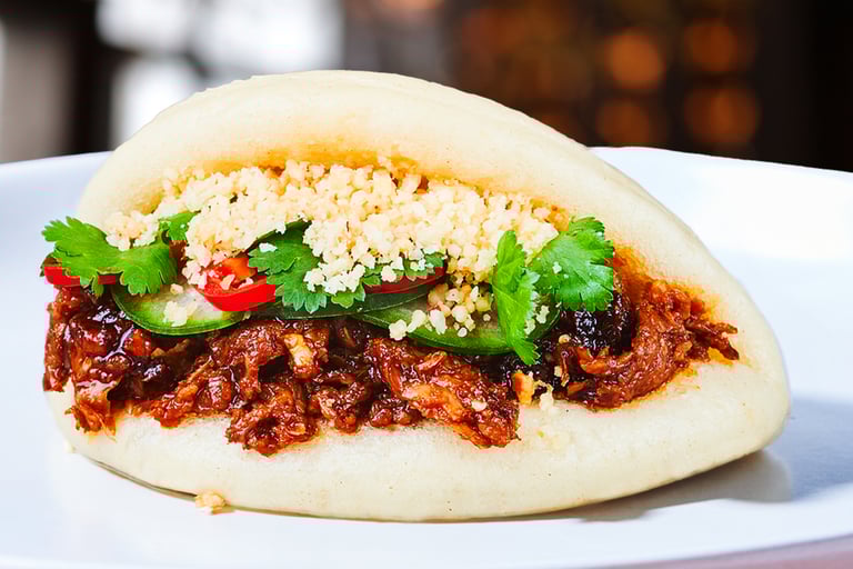 vegan bao bun stuffed with korean vegan meat on a plate