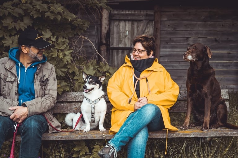 Martin & Marion Lindhof auf einer Bank mit 2 Hunden