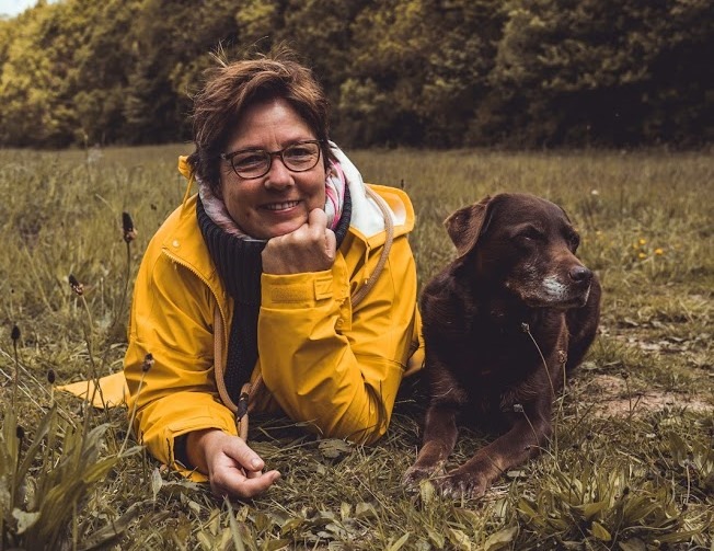 Marion Lindhof von Hunde Freude mit ihrer verstorbenen Labradorhündin Amy auf einer Wiese.