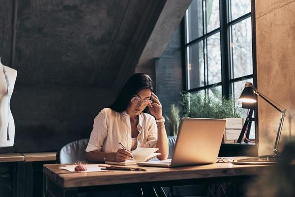 imagem ilustra uma empresária sentada na cadeira trabalhando em Home office.