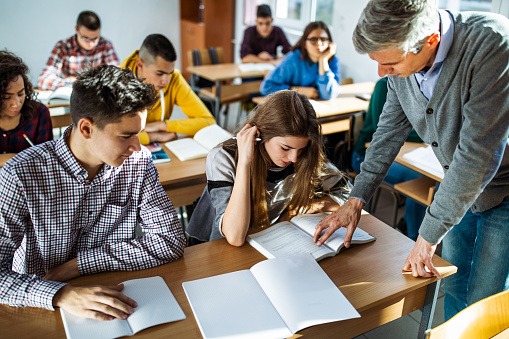 imagem de uma sala de aula com alunos interagindo com o professor