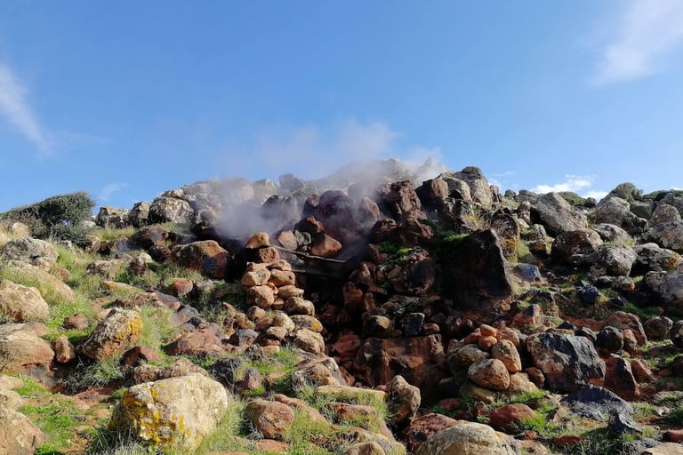Favara Grande in Pantelleria with steam rising among volcanic rocks and natural vegetation
