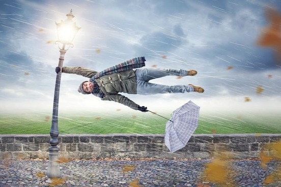 heavy wind with person holding onto pole