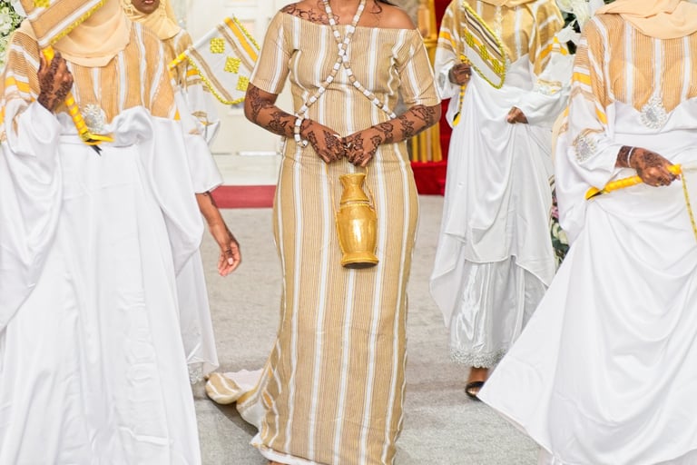 Happy Somalian bride and bridesmaids entering wedding venue all in traditional white & gold dresses, floral arch framing them