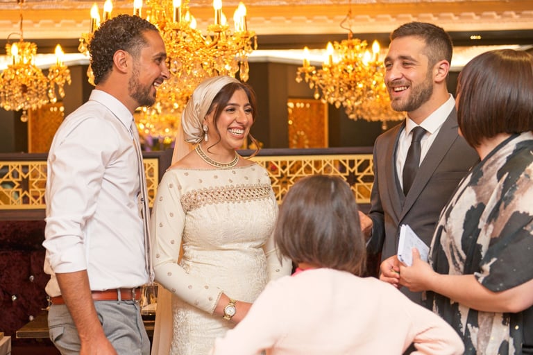 bride, groom and grooms man all laughing and smiling in a fancy restaurant