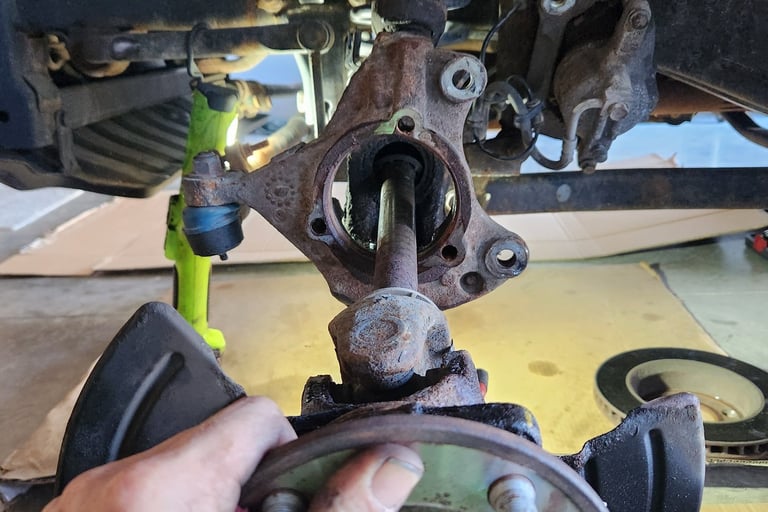 Fast T's Axle Technician removing an axle from the front differential in a customers garage