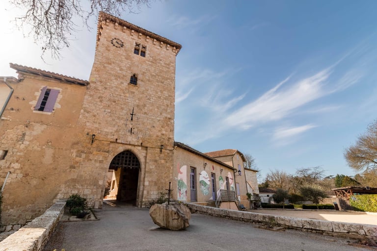Entrée de la bastide de Sarrant sous un ciel bleu, mise en valeur du patrimoine gersois en photo