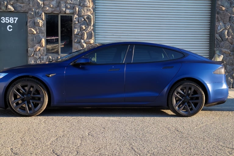 Satin PPF wrap on a blue Tesla MS with dark tint, expertly installed in the shop.