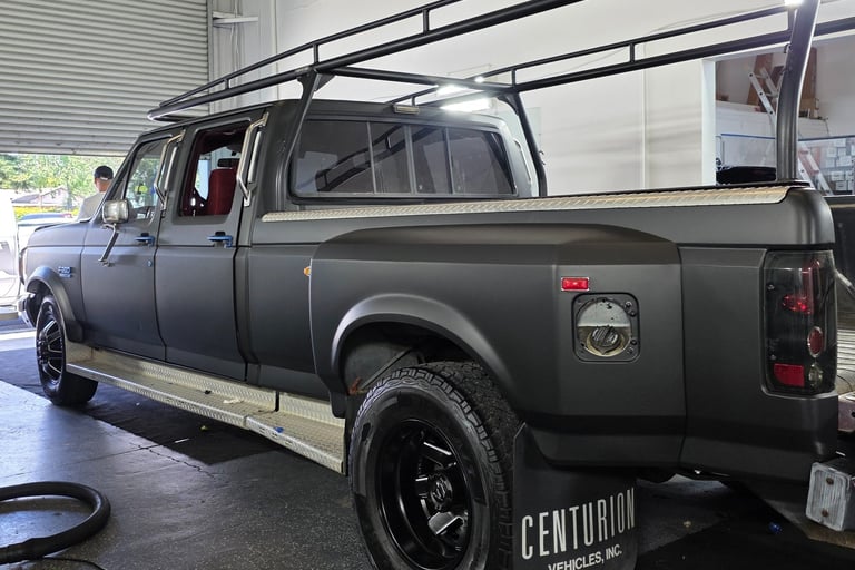 black matte vinyl wrap on a ford F350 with dark wheels, expertly installed in the shop.