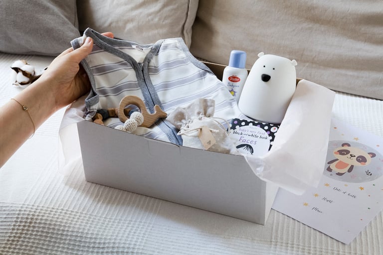 A box with a toy, book, pyjamas and a sun screen.