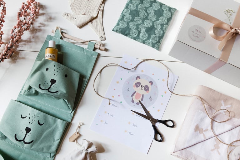 Ein Flatlay mit einem Kissen, Öl, einem Lätzchen, einer Decke und Wandtaschen.