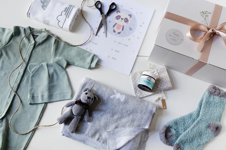 Flat lay with a bear, blanket, socks, pyjamas and cream.