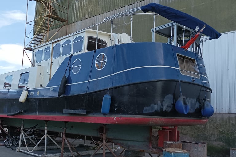 A double width canal going boat with a British ensign flag