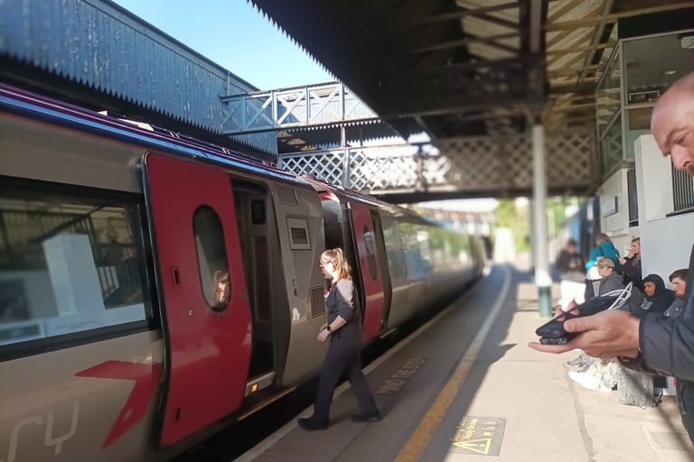The train manager has blown her whistle and returns to the carriage