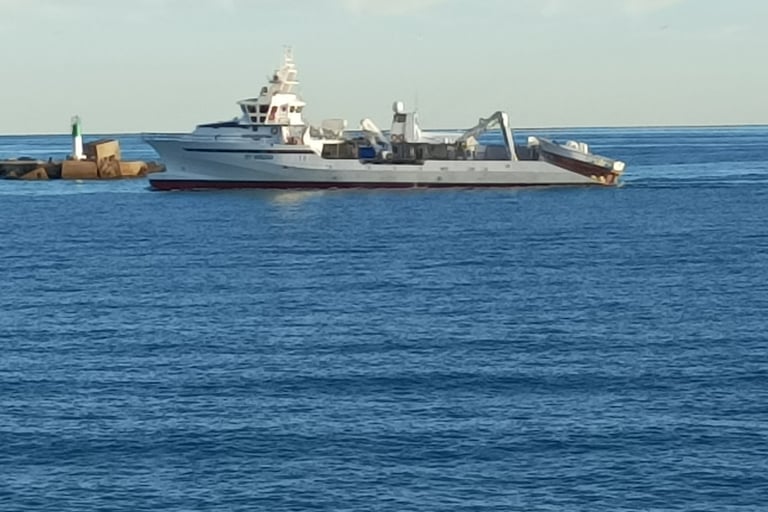 A Larger Trawler heads into Port