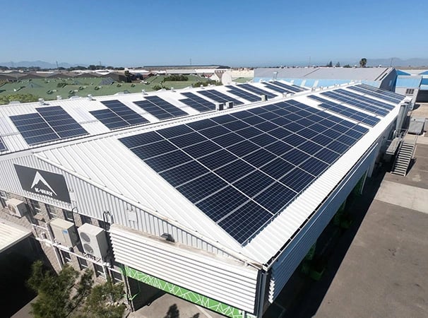 Commercial rooftop solar panel installation on an industrial warehouse building for renewable energy.