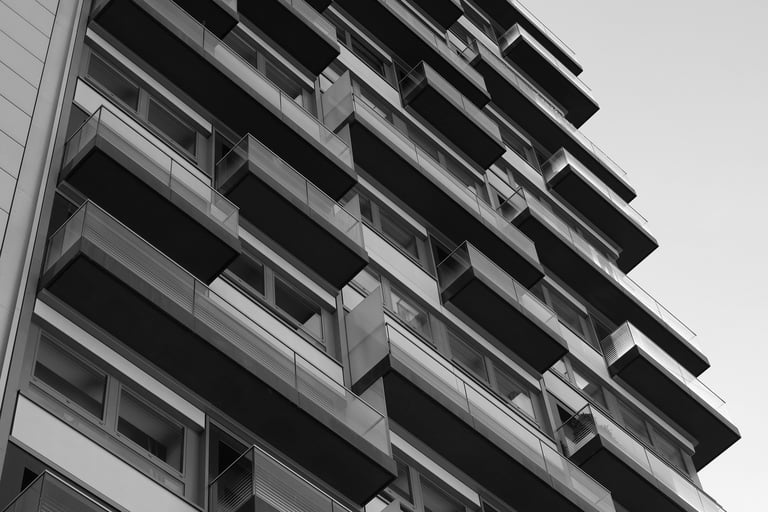 Modern apartman binası, simetrik balkon dizilimiyle siyah-beyaz çekim
