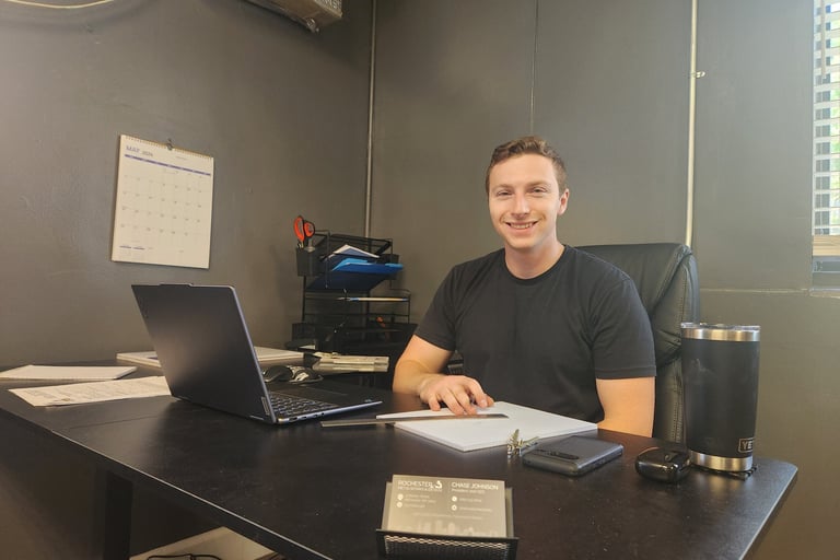 man sitting at office desk smiling
