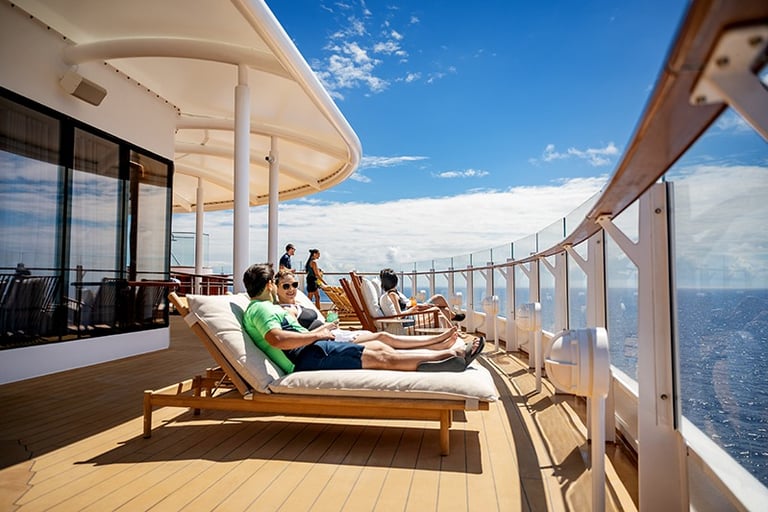 Adults relax on the deck of Disney Cruise Line