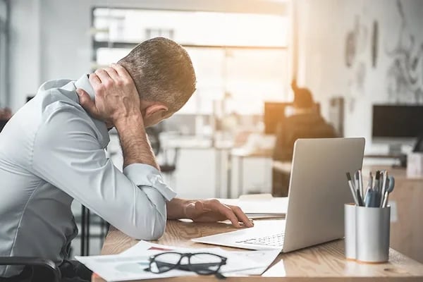 Small business owner buried in paperwork, overwhelmed before Cilson Bookkeeping help
