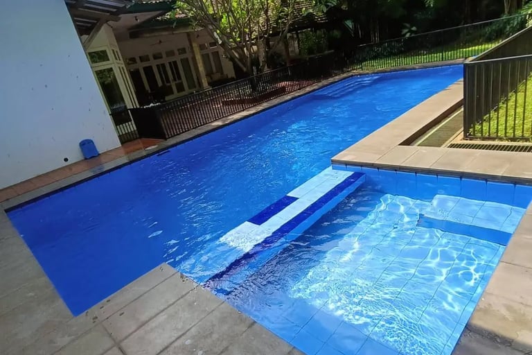 Kolam renang air hangat minimalis dengan dek kayu di halaman belakang rumah Karawang