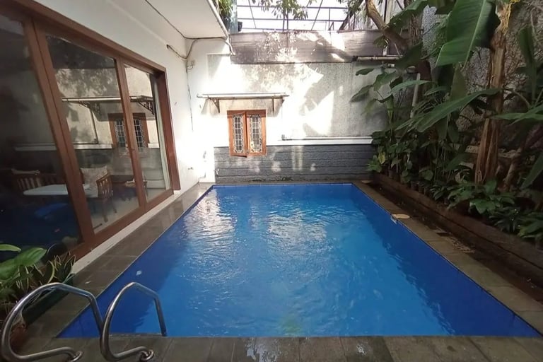 kolam renang di halaman belakang yang indah dan menyegarkan dengan keramik berwarna biru